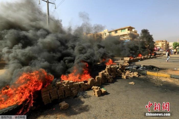 當?shù)貢r間10月25日，蘇丹局勢發(fā)生突變，過渡政府總理被“綁架”，政府部長被軍方抓捕，國家進入緊急狀態(tài)，大量民眾走上街頭對軍方行動進行抗議，已有7人在抗議活動中死亡，140人受傷。圖為抗議活動中燃燒的輪胎。