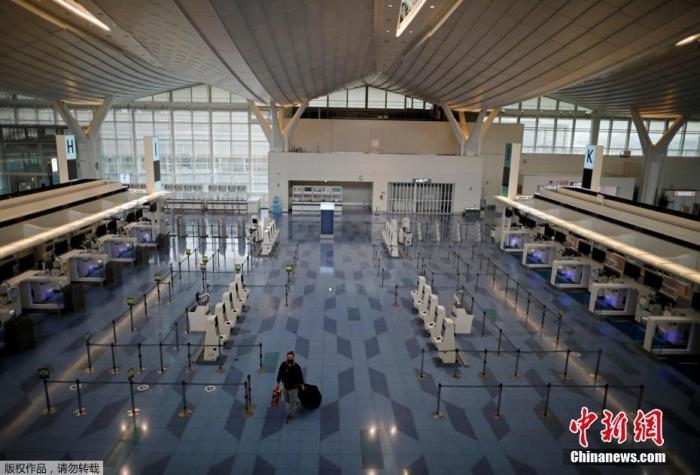 資料圖：日本東京，東京國際機(jī)場，一名乘客在國際航班航站樓的登機(jī)區(qū)。