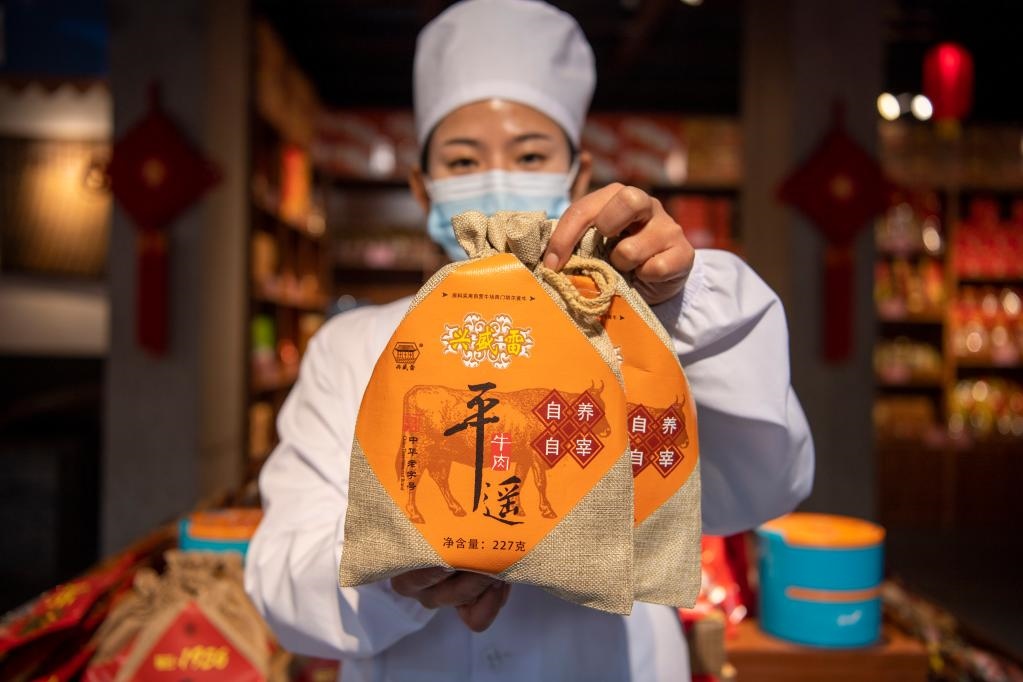 1月27日，在平遙古城南大街的一家平遙牛肉店內(nèi)，工作人員展示一款牛肉產(chǎn)品。新華社記者 楊晨光 攝