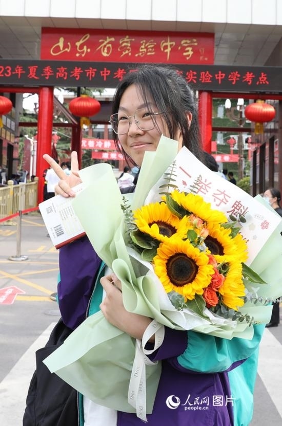 6月7日高考首日，山東67萬考生走進(jìn)考場(chǎng)，拼搏逐夢(mèng)。在山東省實(shí)驗(yàn)中學(xué)考點(diǎn)，考生進(jìn)考場(chǎng)前手捧向日葵花拍照留念，寓意“一舉奪魁”。人民網(wǎng)記者 劉祺攝