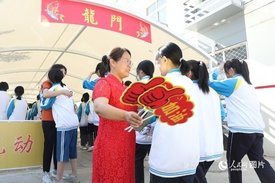 6月7日一早，雄安新區(qū)安新中學(xué)老師在給同學(xué)們加油鼓勁兒。人民網(wǎng) 李兆民攝