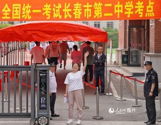 6月7日，在長春市第二中學(xué)考點(diǎn)，一名考生信心滿滿進(jìn)入考場(chǎng)，并與家長揮手致意。人民網(wǎng)記者 李洋攝