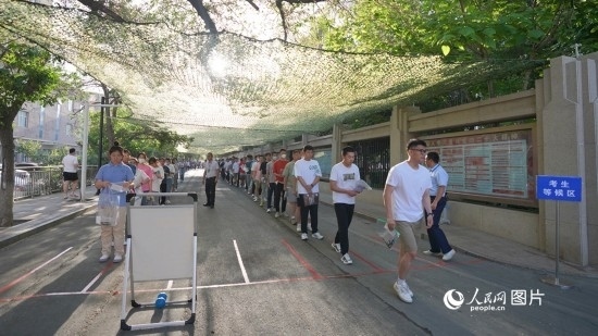 6月7日，烏魯木齊市第七十中學(xué)門口，考生們有序進(jìn)入考場(chǎng)。人民網(wǎng) 李欣洋攝