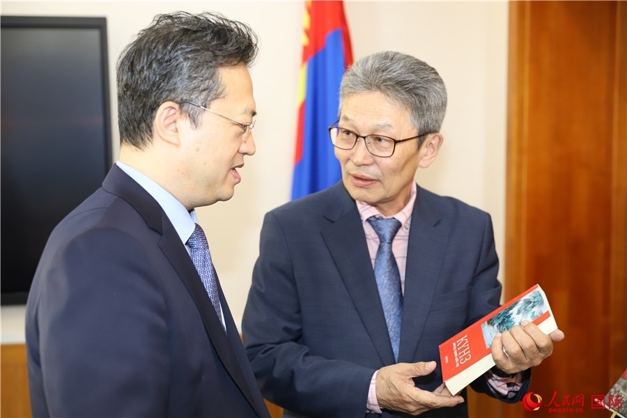 其米德策耶（右一）向李峙介紹翻譯成果。人民網(wǎng)記者 霍文攝