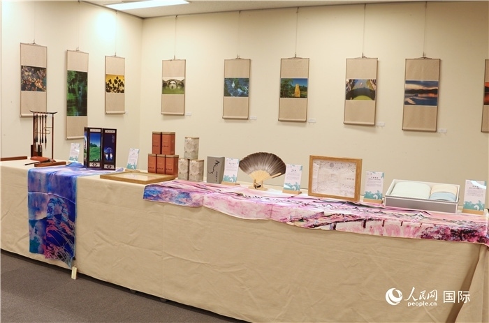 現(xiàn)場展出的馮學(xué)敏攝影作品與湖州市特色工藝品。（人民網(wǎng) 許可攝）