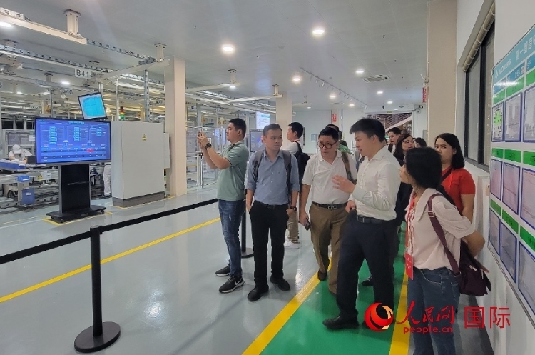 廣汽埃安工作人員向外媒記者進行介紹。人民網 寧玉瑛攝