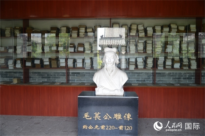 河間詩經(jīng)齋毛萇雕像。雕像后書櫥中陳列的是歷代各版本《詩經(jīng)》及譯本。 人民網(wǎng) 趙昭攝