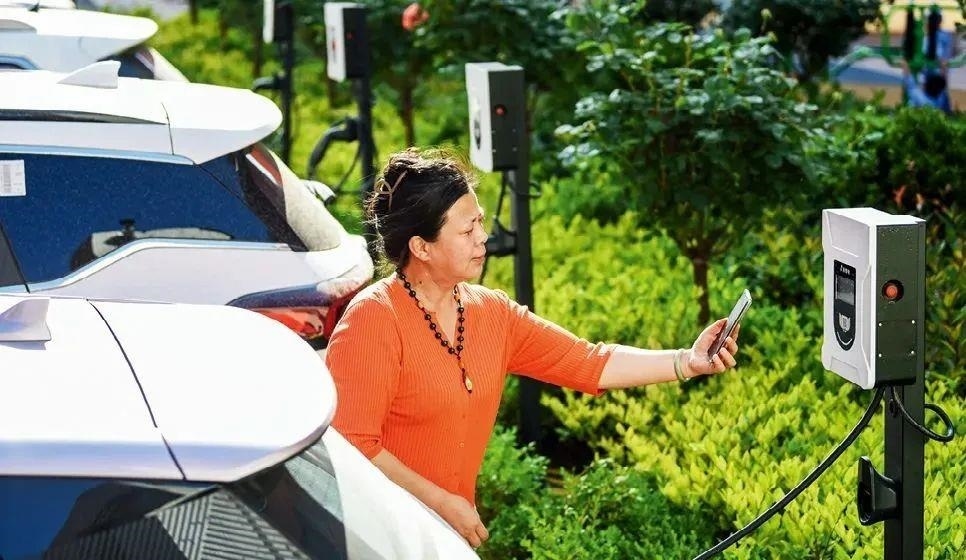 2023年5月24日，山東省膠州市新立街小區(qū)內(nèi)一位居民使用電動汽車充電樁掃碼充電。該小區(qū)加裝各類智慧設(shè)備，打造“智慧社區(qū)”，為居民生活帶來便利。