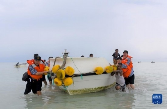7月21日，中國海軍“和平方舟”號醫(yī)院船醫(yī)護(hù)人員涉水登島，前往基里巴斯一診療點(diǎn)。新華社記者 黎云 攝