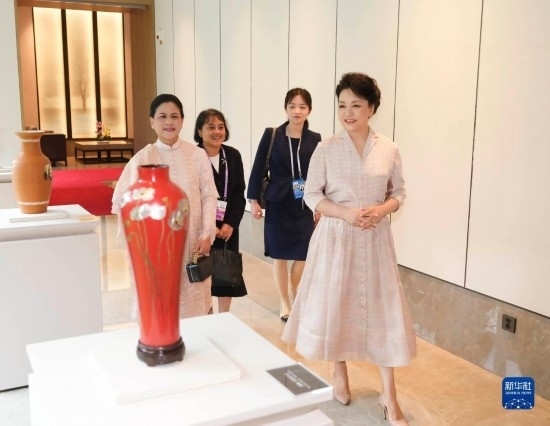 7月27日下午，國(guó)家主席習(xí)近平夫人彭麗媛在四川成都會(huì)見(jiàn)陪同印度尼西亞總統(tǒng)佐科來(lái)華出席第31屆世界大學(xué)生夏季運(yùn)動(dòng)會(huì)開(kāi)幕式并訪華的總統(tǒng)夫人伊莉亞娜。這是彭麗媛和伊莉亞娜欣賞成都特色非遺工藝品。新華社記者 丁林 攝