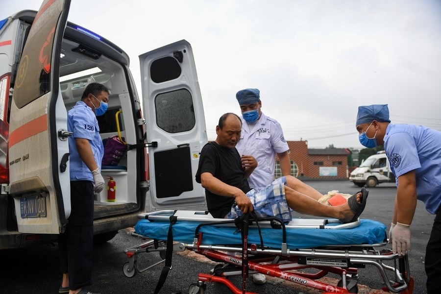 8月1日，在北京市門頭溝區(qū)妙峰山鎮(zhèn)妙峰山民族學校臨時安置點，北京急救中心工作人員在轉運一名受傷村民。新華社記者 鞠煥宗 攝
