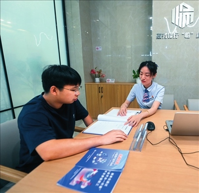 在杭州市臨安區(qū)政務(wù)服務(wù)中心的“為企服務(wù)中心”，黨員志愿者（右）解答企業(yè)主的疑問(wèn)（2023年7月7日攝）。徐昱攝/本刊