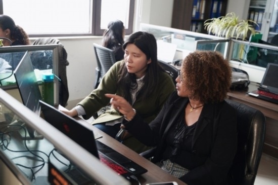 梅德哈妮（右）與中國同事討論設(shè)計方案。受訪對象供圖