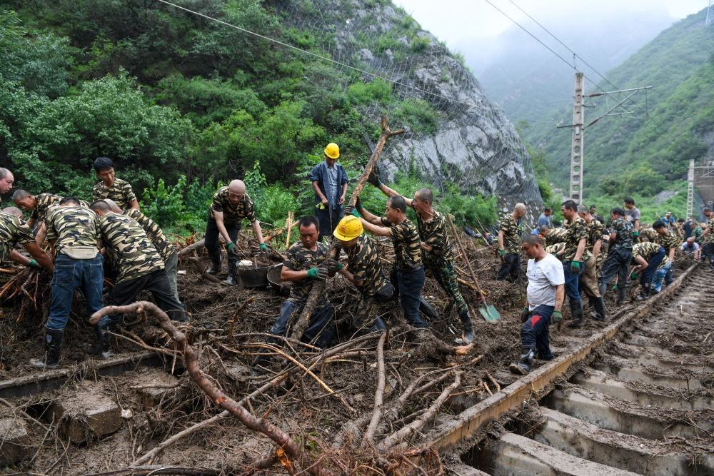 8月1日，在北京市門頭溝區(qū)水峪嘴村附近一段被阻斷的鐵路線上，中鐵六局工作人員在清理軌道上的雜物，全力恢復交通。新華社記者 鞠煥宗 攝