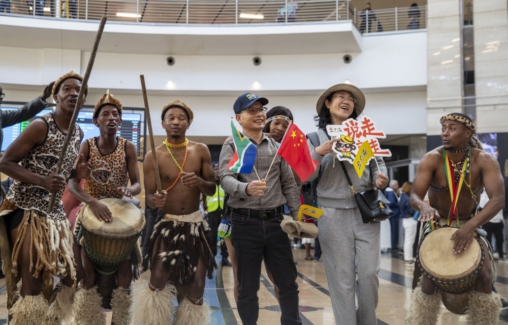 在南非約翰內(nèi)斯堡坦博國(guó)際機(jī)場(chǎng)，南非舞蹈演員歡迎中國(guó)試點(diǎn)恢復(fù)出境團(tuán)隊(duì)旅游后首批抵達(dá)南非的中國(guó)游客（2023年3月29日攝）。