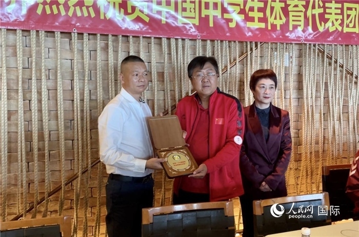 巴西中國和平統(tǒng)一促進會會長王俊曉向中國中學(xué)生體育代表團團長劉立新贈送紀(jì)念品。人民網(wǎng)記者 宋亦然攝