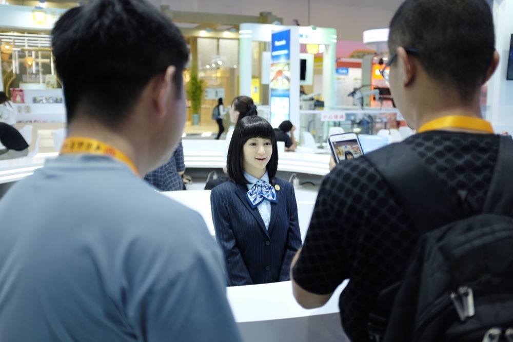 9月1日，媒體記者在國(guó)家會(huì)議中心與服務(wù)機(jī)器人互動(dòng)。新華社記者 劉夢(mèng)琪 攝