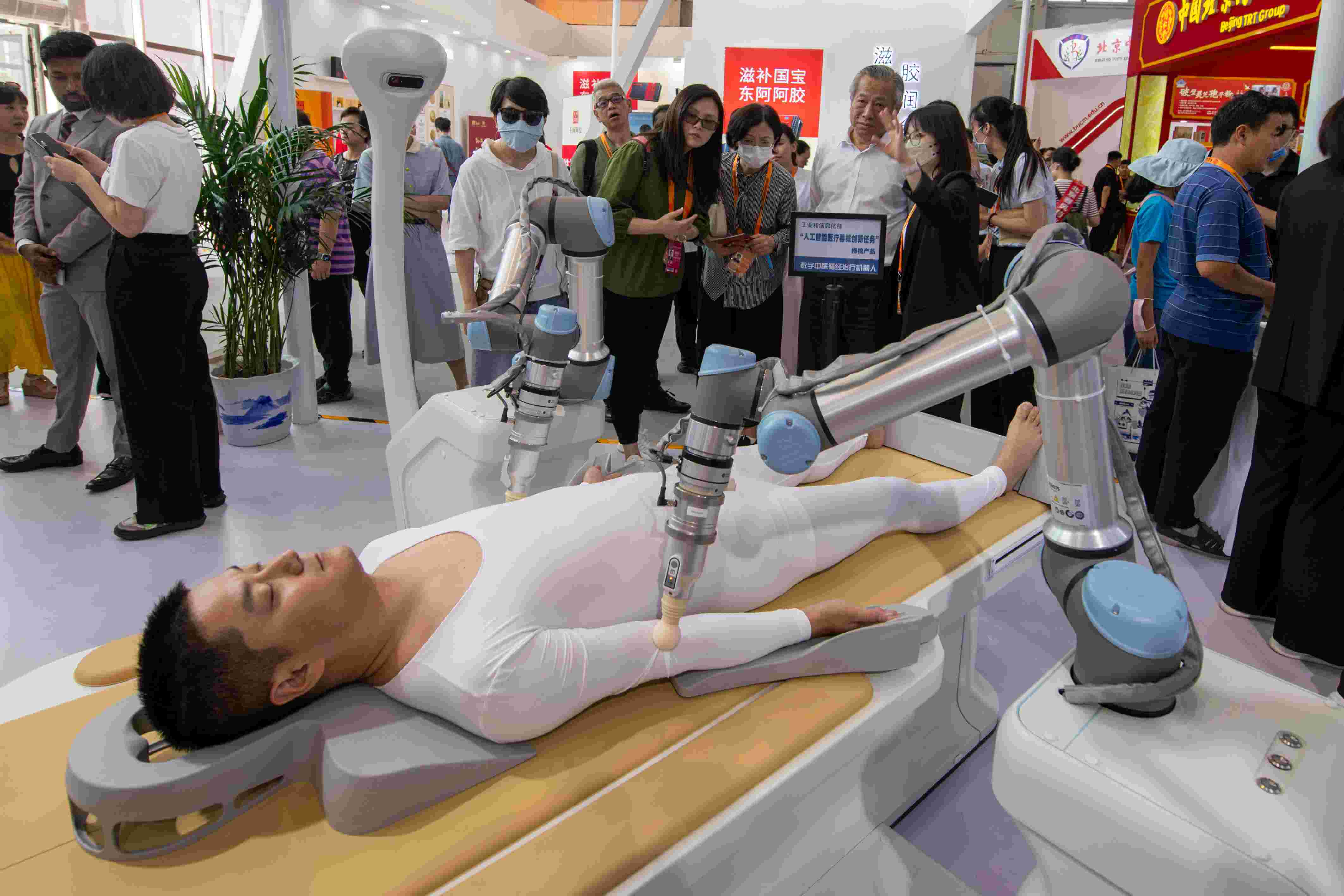 在位于首鋼園的健康衛(wèi)生服務(wù)展區(qū)，觀眾正在參觀數(shù)字中醫(yī)循經(jīng)治療機(jī)器人。人民網(wǎng)記者 翁奇羽攝