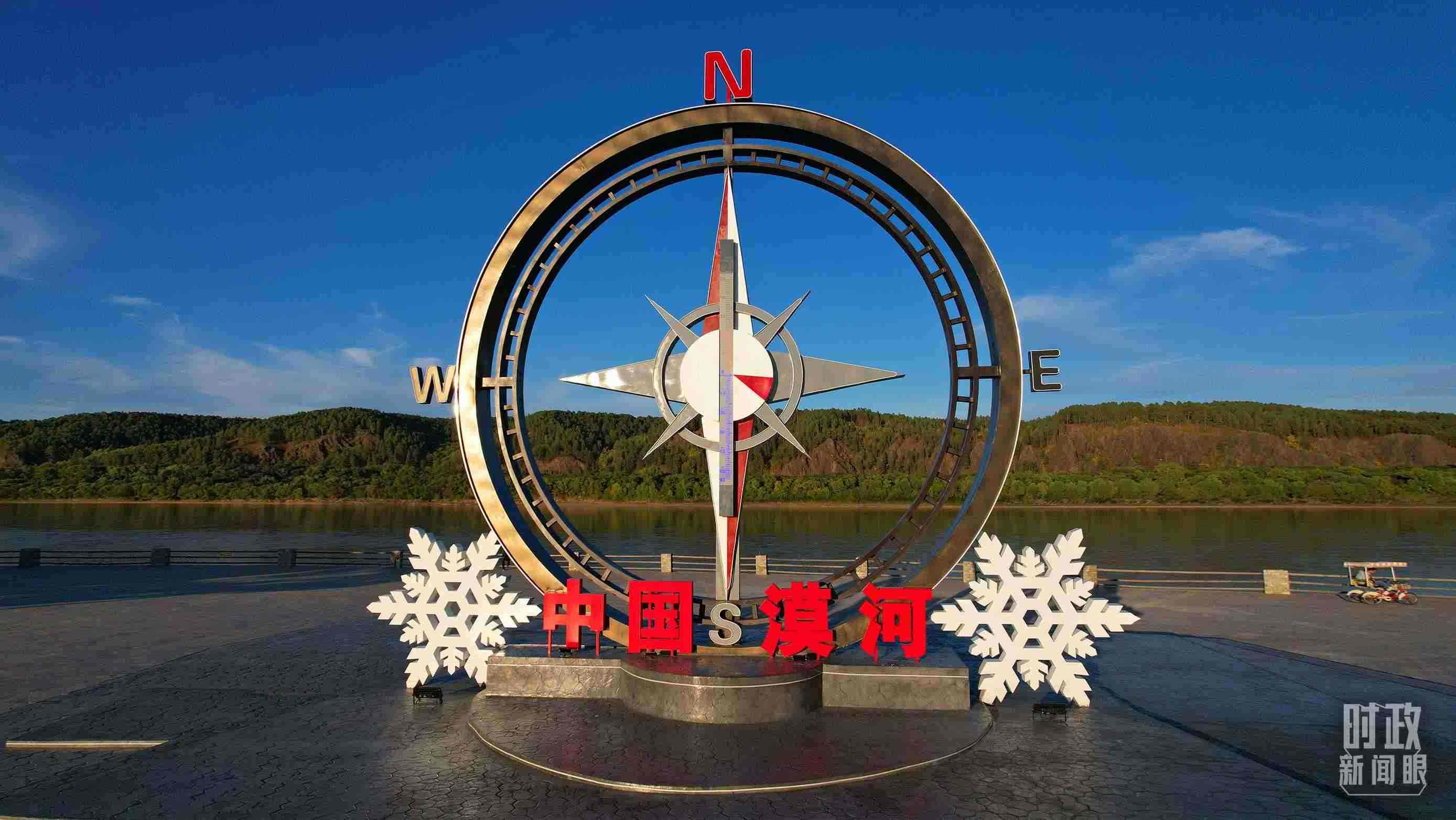 △指北針雕塑是北極村標志性建筑之一，其紅色指針指向正北方。上面的大型溫度計高12.22米，象征北極村位于東經(jīng)122°20′。（總臺央視記者范凱拍攝）