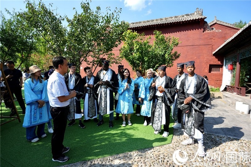 圖為選手們聽(tīng)導(dǎo)游講解。人民網(wǎng) 盧鵬宇攝