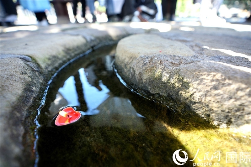 圖為水渠里流過(guò)的“桃心”蠟燭。人民網(wǎng) 盧鵬宇攝