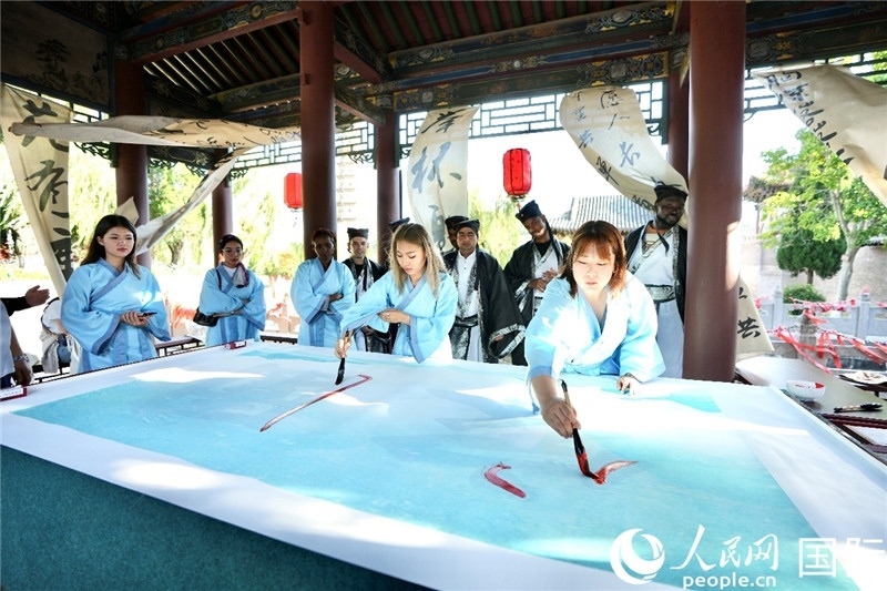 選手們提筆書(shū)寫(xiě)“家園”二字。人民網(wǎng) 盧鵬宇攝