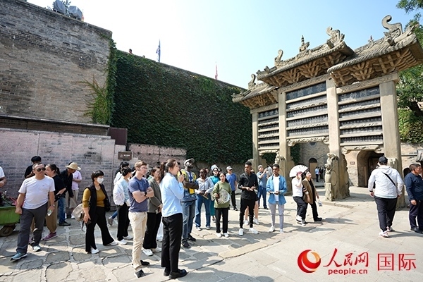 選手們認(rèn)真聆聽導(dǎo)游講解。人民網(wǎng) 盧鵬宇攝