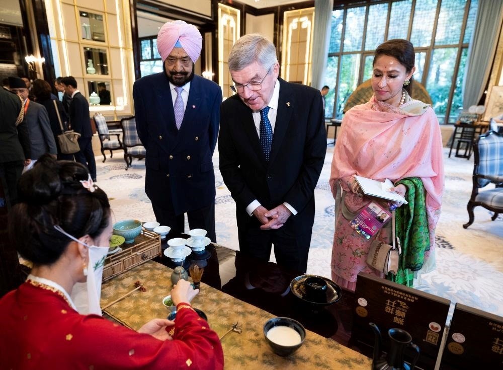 △歡迎宴會前，亞奧理事會代理主席辛格和夫人維尼塔、國際奧委會主席巴赫欣賞非遺展示。