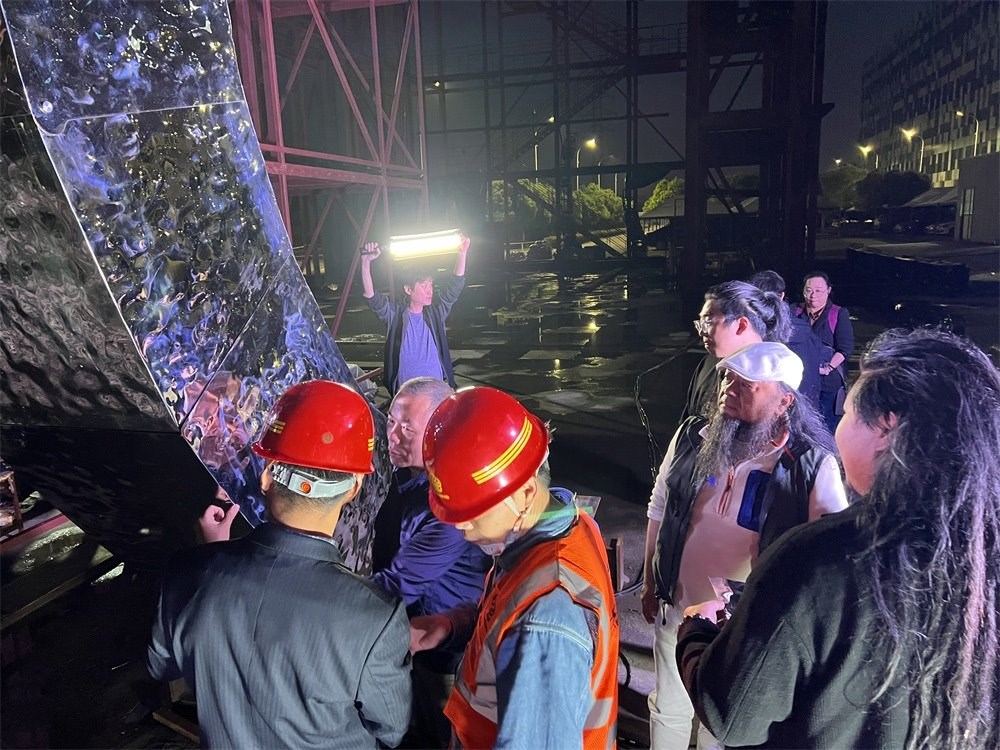 林崗（右二）和團隊查看主火炬制作進度。受訪者供圖