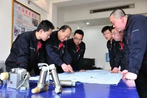 △李志強(qiáng)（左二）與班組成員在研究工作。