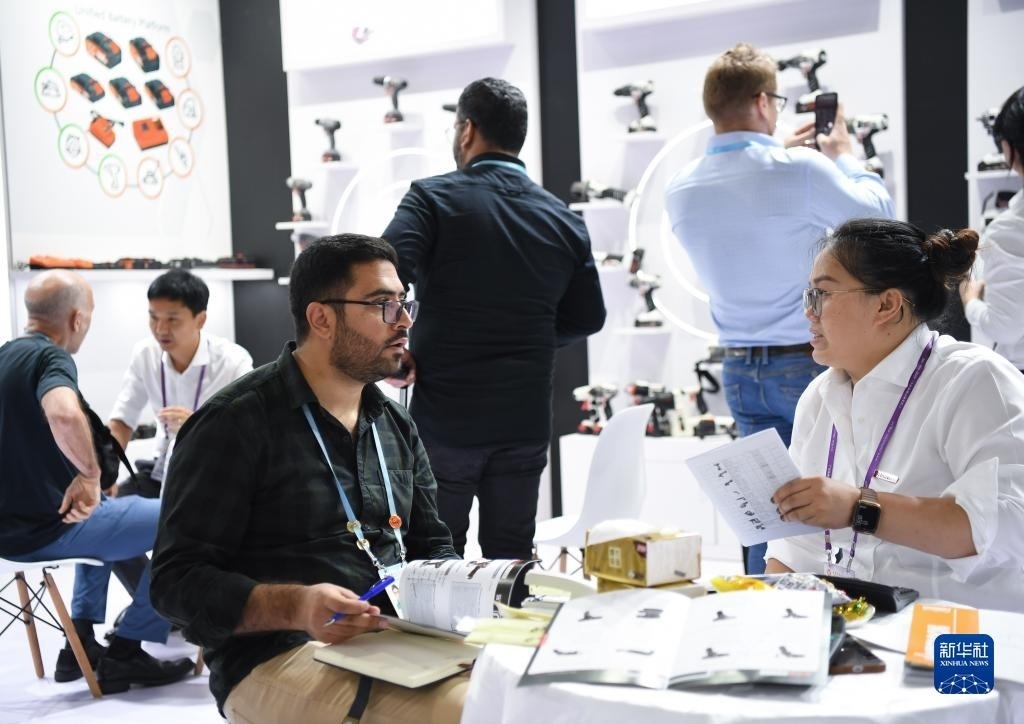 10月15日，在一家電動工具展臺，外國采購商在洽談業(yè)務(wù)。新華社記者 鄧華 攝