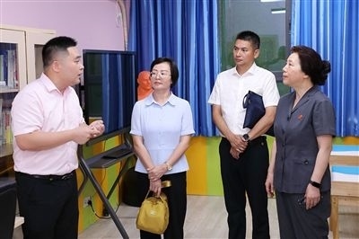 圖③：“小公民法律課堂”開講前，全國人大代表殷其龍（右二）、重慶市人大代表李自玲（左二）聽取楊家坪中學負責人關(guān)于未成年人思想教育工作情況的介紹。