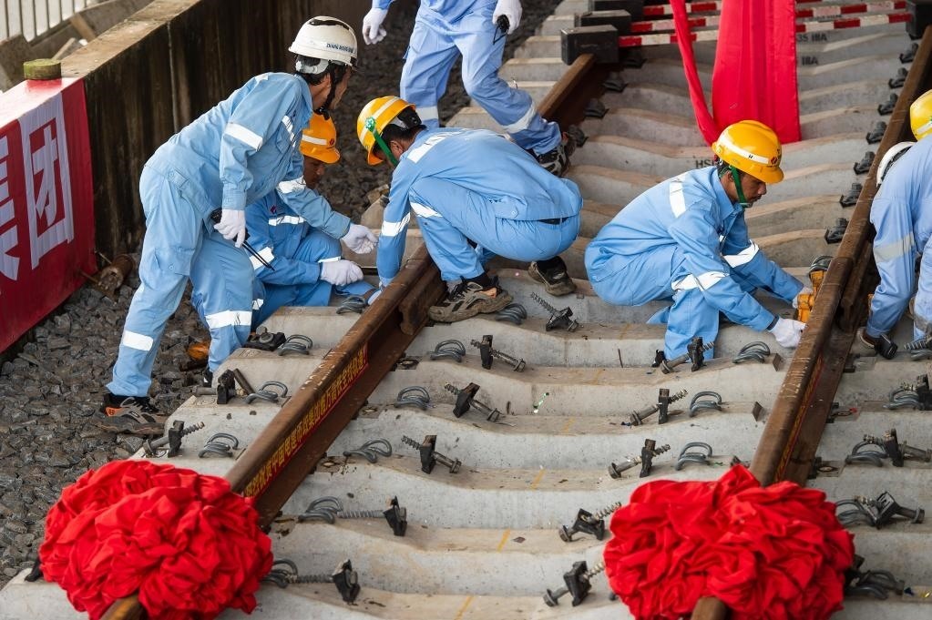 3月31日，在印度尼西亞雅加達(dá)雅萬高鐵哈利姆車站，工人鋪設(shè)雅萬高鐵全線最后一根鋼軌。