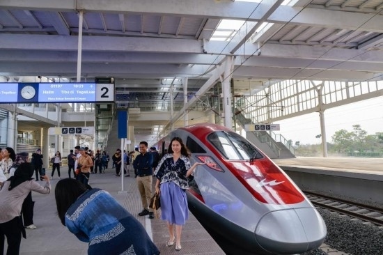  10月17日，在印度尼西亞萬隆德卡魯爾站，乘客在站臺上和雅萬高鐵高速動車組列車合影。新華社記者 徐欽 攝