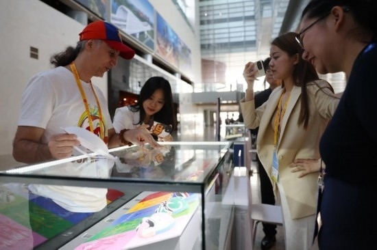 10月16日，參會記者在“一帶一路”國際合作高峰論壇新聞中心參觀展示的中國非物質文化遺產展品。新華社記者 陳斌 攝