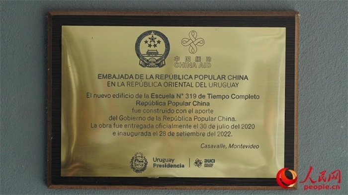 小學(xué)墻上懸掛的中國(guó)援助標(biāo)識(shí)。人民網(wǎng)記者 張若涵攝