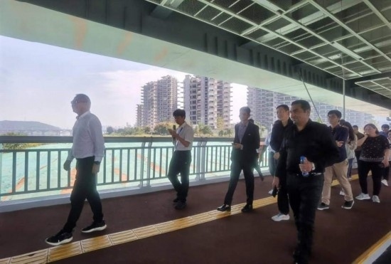 10月24日，2023“一帶一路”媒體合作論壇聯(lián)合采訪團(tuán)團(tuán)員走在清水塘大橋景觀通道上。本報(bào)記者 常雯宜攝