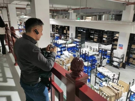 2023“一帶一路”媒體合作論壇聯(lián)合采訪團(tuán)團(tuán)員在仁和醫(yī)藥物流園拍攝記錄轉(zhuǎn)運(yùn)流程。（本報(bào)記者 黃超攝）