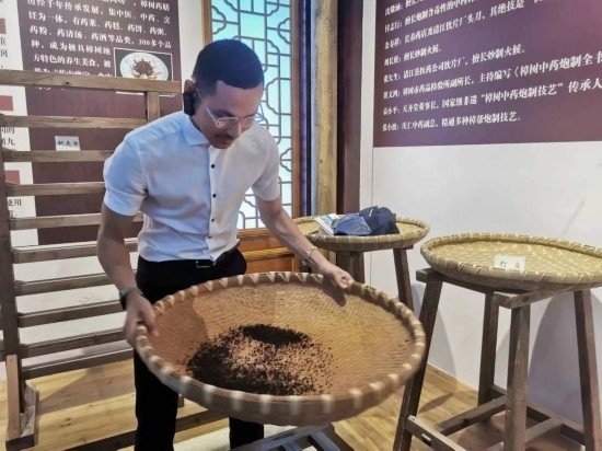 2023“一帶一路”媒體合作論壇聯(lián)合采訪團(tuán)團(tuán)員在非遺文化展示館體驗(yàn)中藥炮制技藝。（本報(bào)記者 黃超攝）