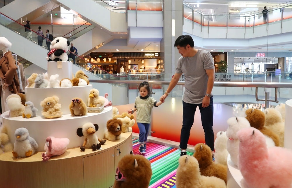 2023年11月2日，顧客在溫暖駝品牌專柜內(nèi)選購。連續(xù)六年參加進(jìn)博會(huì)的秘魯羊駝制品品牌溫暖駝在上海市中心商場(chǎng)開設(shè)了專柜。新華社記者 方喆 攝