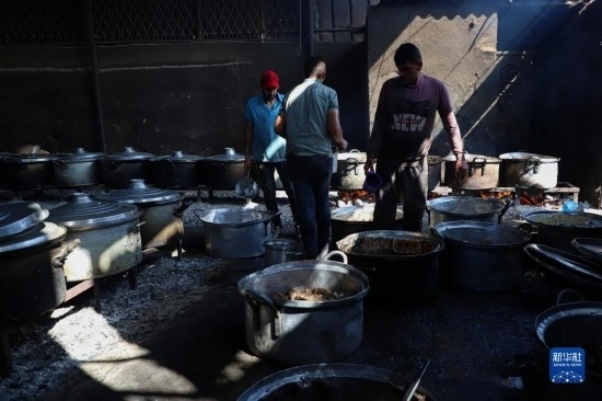 11月3日，在加沙地帶南部城市拉法，人們?cè)诿簹庵袛嗪笥貌窕鹱鲲?。新華社發(fā)（里澤克·阿卜杜勒賈瓦德攝）