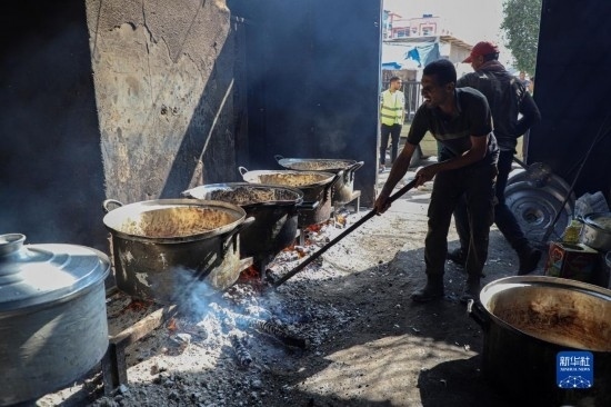 11月3日，在加沙地帶南部城市拉法，人們?cè)诿簹庵袛嗪笥貌窕鹱鲲?。新華社發(fā)（里澤克·阿卜杜勒賈瓦德攝）