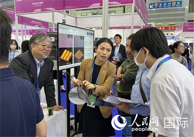 工作人員向參觀者介紹超級(jí)噴墨技術(shù)。（人民網(wǎng)記者 陳思攝）