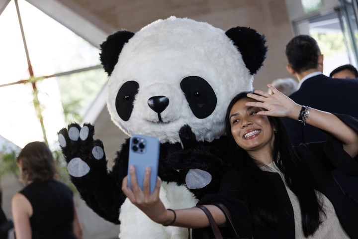 2022年8月24日，在美國華盛頓中國駐美國大使館，來賓與大熊貓玩偶合影。