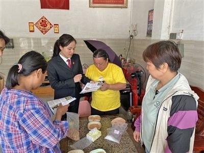  圖⑤：龍圩區(qū)法院法官到群眾家中開展法治宣傳。資料圖片