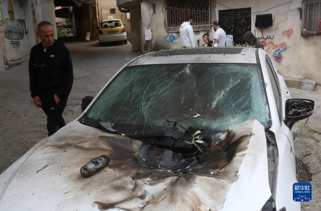 12月17日，在約旦河西岸城市圖勒凱爾姆附近的一處難民營(yíng)，人們查看在沖突中損毀的車輛。新華社發(fā)（尼達(dá)爾·艾仕塔耶?dāng)z）
