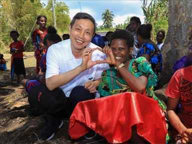 2023年12月18日，中國駐瓦努阿圖大使李名剛和前來觀看瓦努阿圖公路項目二期馬勒庫拉段移交儀式的當?shù)鼐用窈嫌?。人民網(wǎng) 賀吉攝