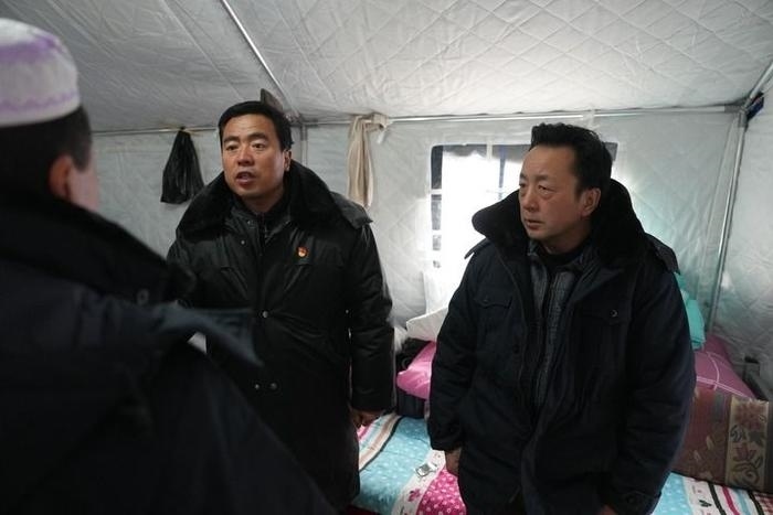 2023年12月22日，積石山縣大河家鎮(zhèn)大河村黨支部書記馬成忠（右二）在帳篷里和受災(zāi)群眾交流。新華社記者 陳斌 攝