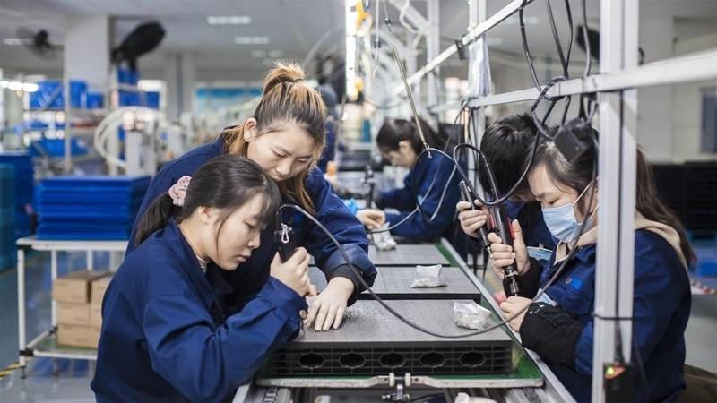 在新亞勝光電的產(chǎn)品線上，工人正進行產(chǎn)品組建和安裝布線。受訪者供圖