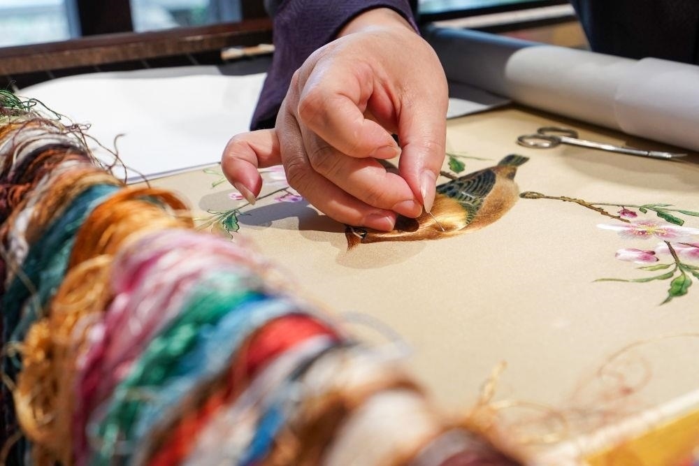 △2023年7月6日，盧建英在江蘇蘇州平江路的工作室內(nèi)刺繡。